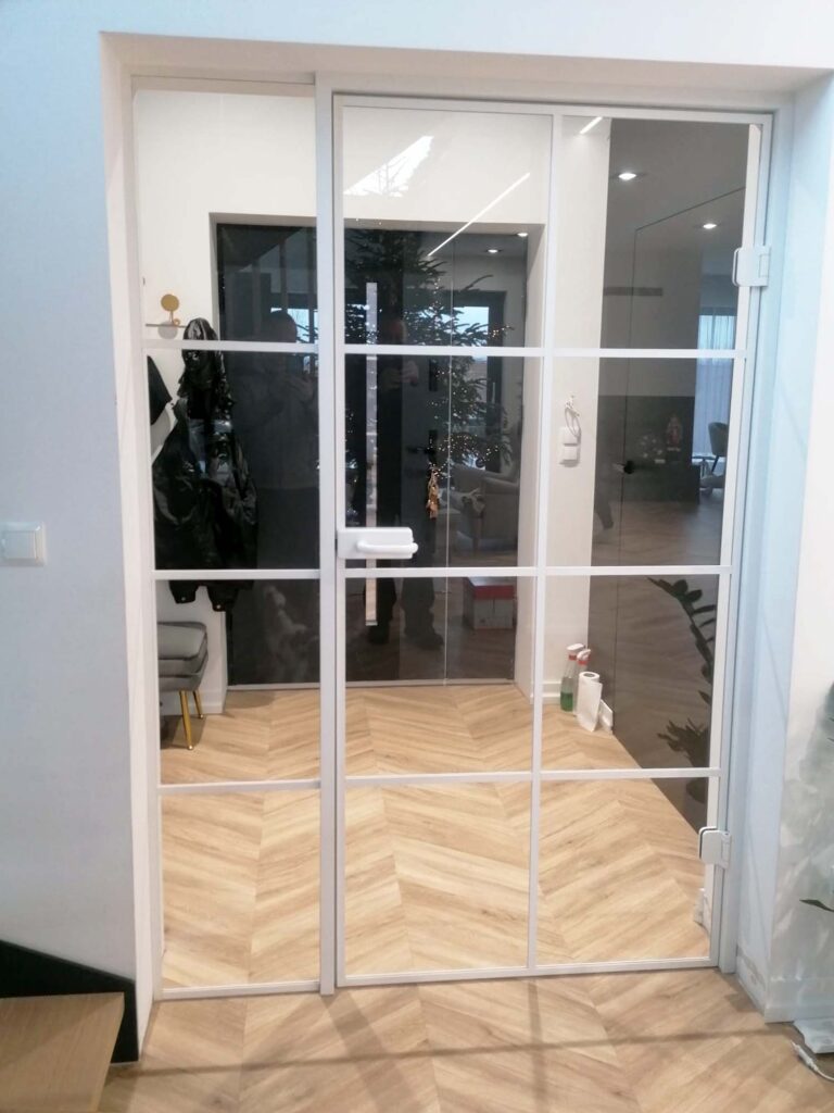 Szklane drzwi w futrynie w białej ramie